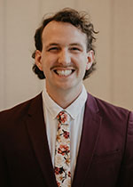 Mia Patrick jordan cox smiling with a suit and tie on