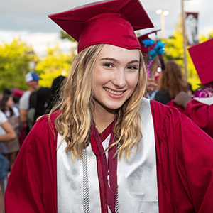 High school student in cap and gown at graduation