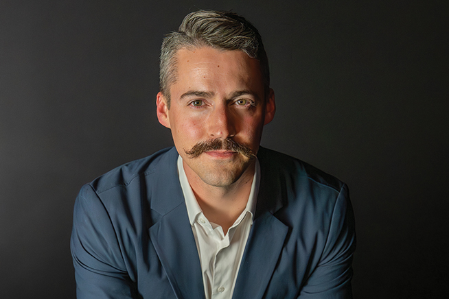 ryan clark leaning forward wearing a suit